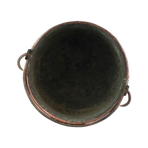 655 - A large copper cauldron or log bin, 19th century. With brass band to rim, and cast iron swing handle... 