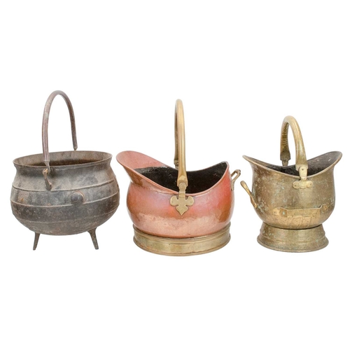 662 - A cast iron cauldron. Of bulbous form, on three feet with angular lugs and a copper handle, the band... 