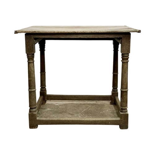 686 - A 17th century oak side table. With a three plank top and raised on gunbarrel turned legs with stret... 