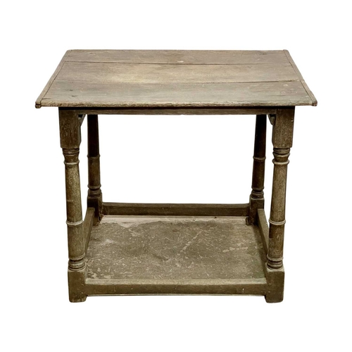 686 - A 17th century oak side table. With a three plank top and raised on gunbarrel turned legs with stret... 