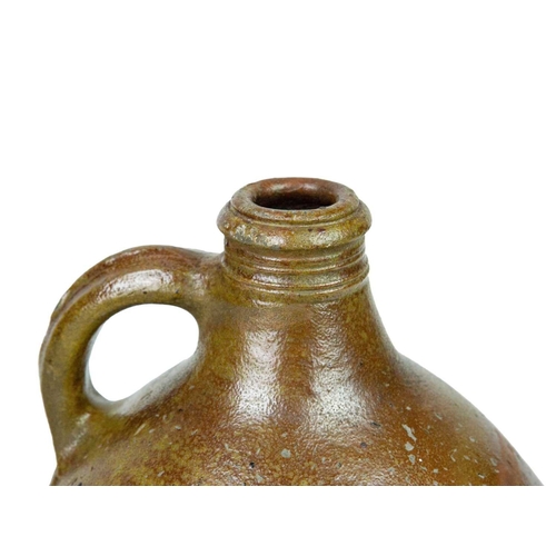 712 - A 17th century German salt-glazed stoneware jug. With a simple loop handle, height 30cm.