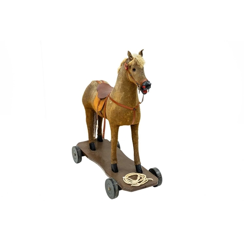 720 - A child's pull-along toy horse. 20th century, fabric covered wood with later saddle, bridle and fitt... 