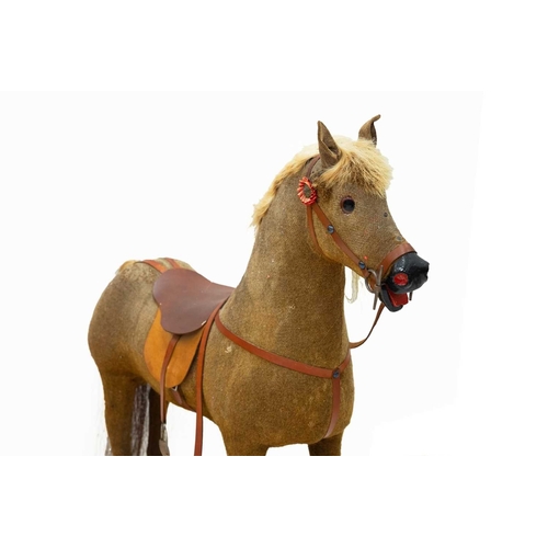 720 - A child's pull-along toy horse. 20th century, fabric covered wood with later saddle, bridle and fitt... 