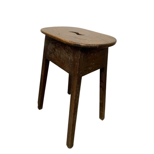 723 - A George III elm and oak stool. The top pierced with a central aperture, raised on square moulded le... 