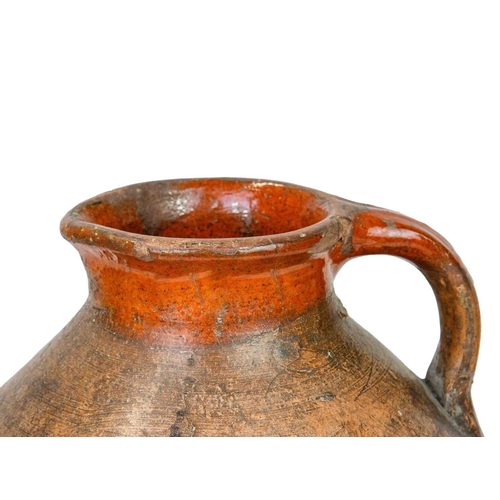 725 - A large pottery storage jug. 18th century, with a broad, rounded body and unglazed exterior, with a ... 