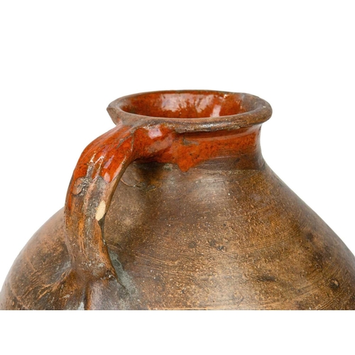 725 - A large pottery storage jug. 18th century, with a broad, rounded body and unglazed exterior, with a ... 