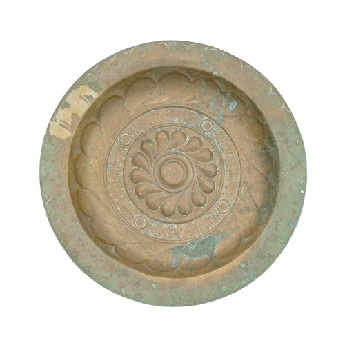 727 - A 17th century Nuremberg brass alms dish. With a central rosette within a Gothic inscription interse... 