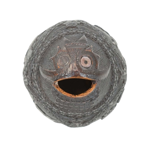 750 - A carved coconut bugbear money box. 19th century, with four carved panels of figures, male and femal... 