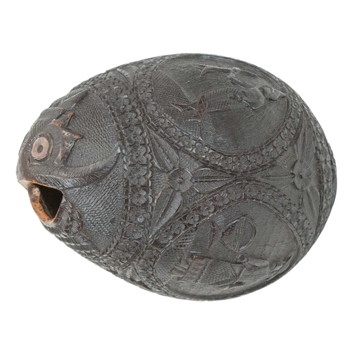 750 - A carved coconut bugbear money box. 19th century, with four carved panels of figures, male and femal... 