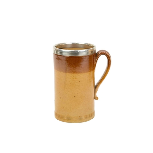 799 - A large Victorian brown salt glazed mug, with a silver mounted rim. Hallmarked London, 1870, height ... 