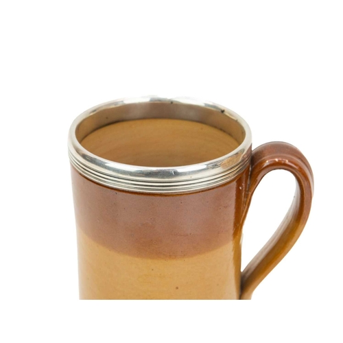 799 - A large Victorian brown salt glazed mug, with a silver mounted rim. Hallmarked London, 1870, height ... 