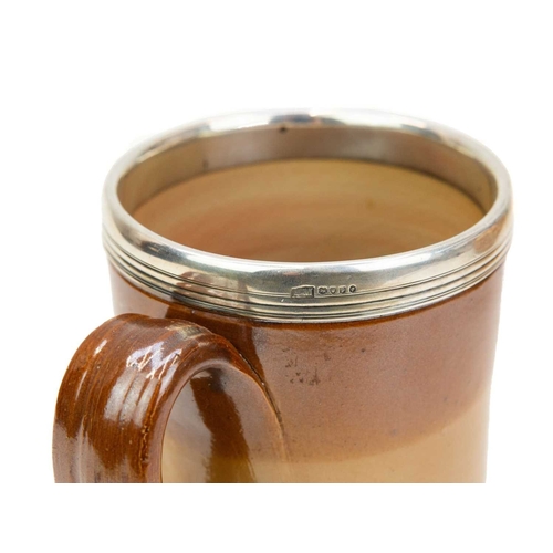 799 - A large Victorian brown salt glazed mug, with a silver mounted rim. Hallmarked London, 1870, height ... 