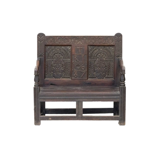 800 - A joined oak hall bench. Partially 17th century, the back with a central panel initialled T R I and ... 