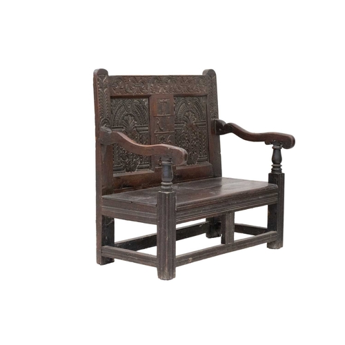 800 - A joined oak hall bench. Partially 17th century, the back with a central panel initialled T R I and ... 