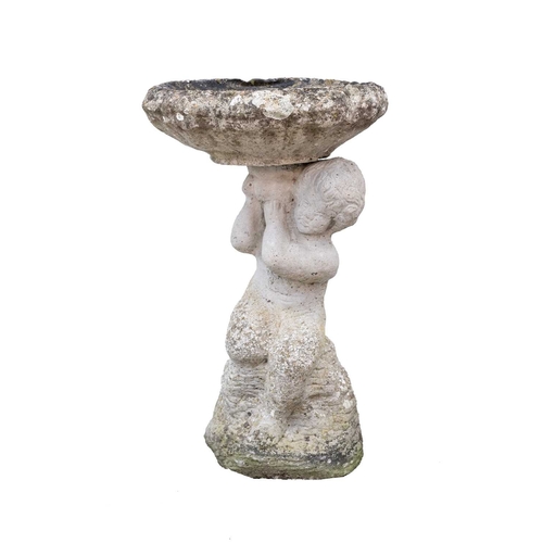 865 - A reconstituted stone bird bath. The figural column cast as a putto holding the water bowl over its ... 