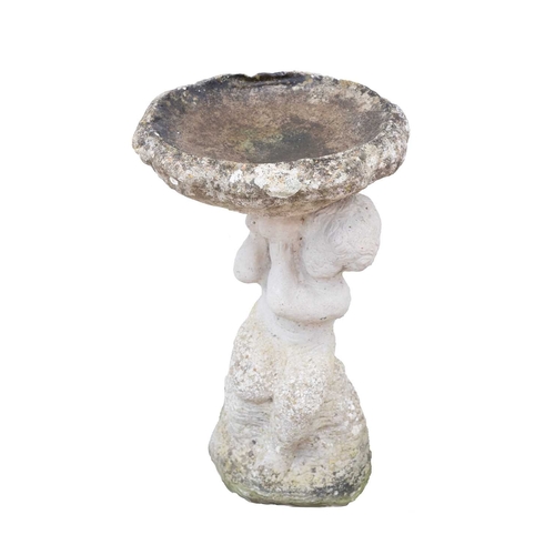 865 - A reconstituted stone bird bath. The figural column cast as a putto holding the water bowl over its ... 