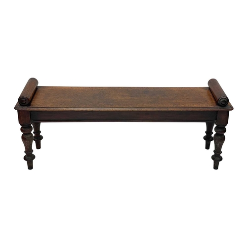 926 - A Victorian mahogany hall bench. The plank top with a moulded edge and cylinder turned ends, raised ... 