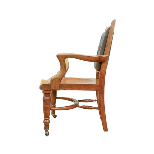 947 - A Victorian walnut desk chair. With a buttoned leather back, carved saddle seat and turned front leg... 