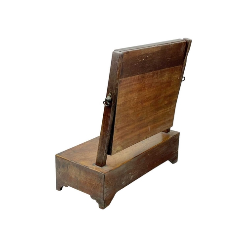 955 - A George III mahogany swing toilet mirror. Of small proportions, the base fitted a single drawer, he... 