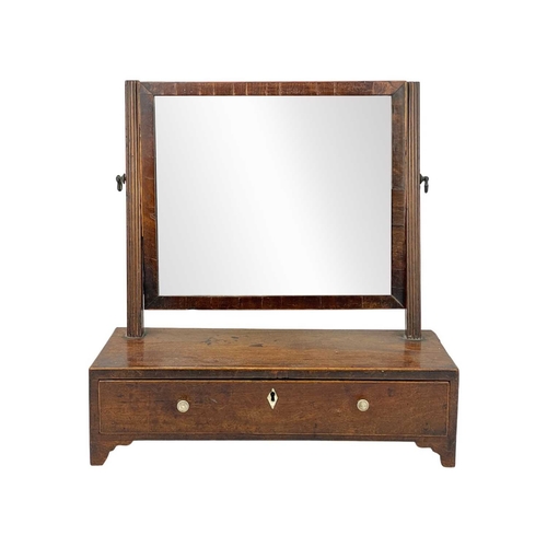 955 - A George III mahogany swing toilet mirror. Of small proportions, the base fitted a single drawer, he... 