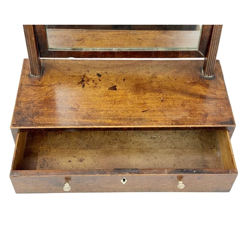 955 - A George III mahogany swing toilet mirror. Of small proportions, the base fitted a single drawer, he... 