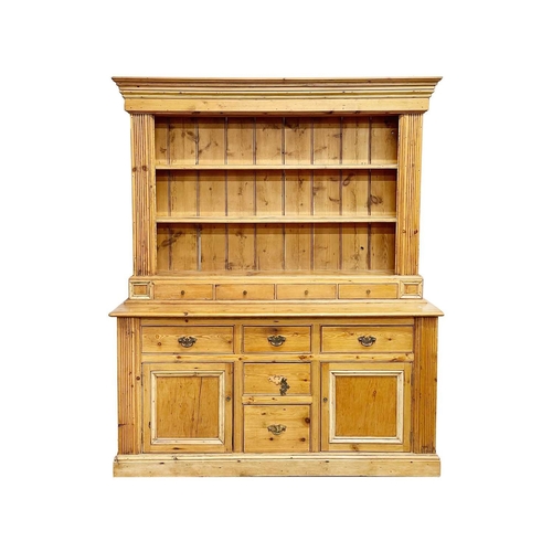 969 - A pine kitchen dresser. The plate rack with two shelves and four spice drawers, the lower part with ... 