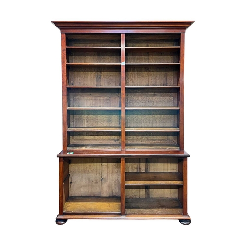 974 - A mahogany two part open bookcase. Late 19th century, with a moulded cornice above a range of adjust... 