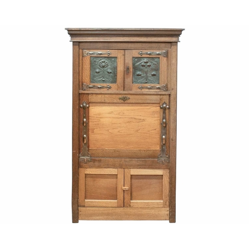 977 - An oak Arts and Crafts cabinet. Fitted with two doors with pressed copper panels and strap hinges, a... 