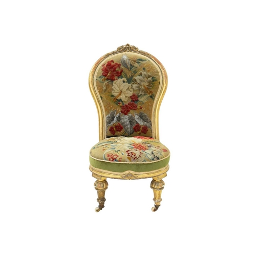 978 - A Victorian giltwood nursing chair. The balloon shape back with carved crest and with woolwork and b... 