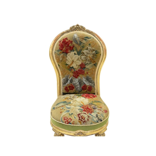 978 - A Victorian giltwood nursing chair. The balloon shape back with carved crest and with woolwork and b... 
