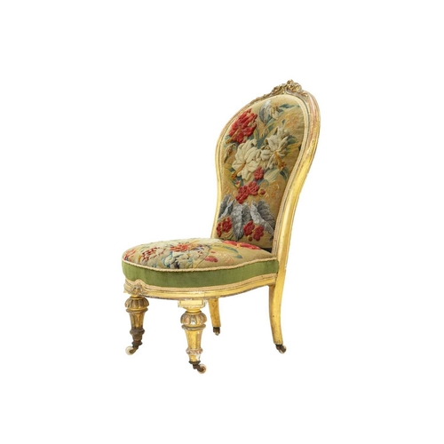 978 - A Victorian giltwood nursing chair. The balloon shape back with carved crest and with woolwork and b... 