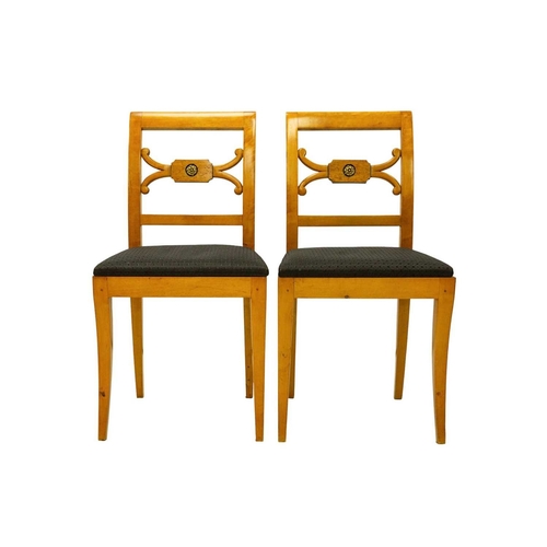 979 - A set of four Biedermeier style dining chairs. The centre rails with burr panels centering a gilt pa... 