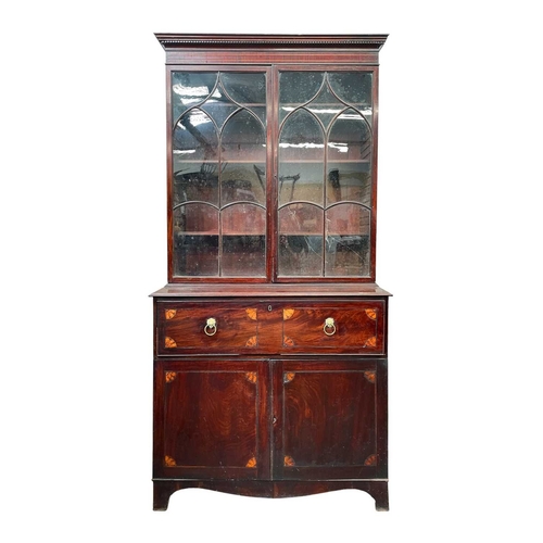 980 - A George III secretaire bookcase. The upper part with two glazed doors, the lower part with a fitted... 