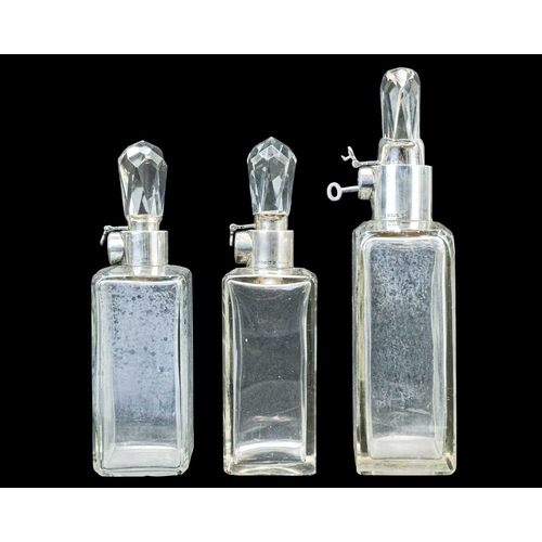 295 - A matched suite of three Hukin & Heath silver mounted locking decanters. George V, each of plain rec... 