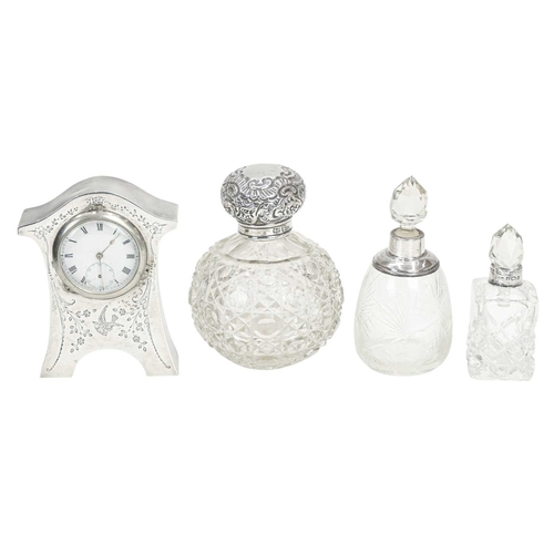 296 - A George V silver mounted boudoir timepiece. Of waisted form with engraved bird and foliate decorati... 