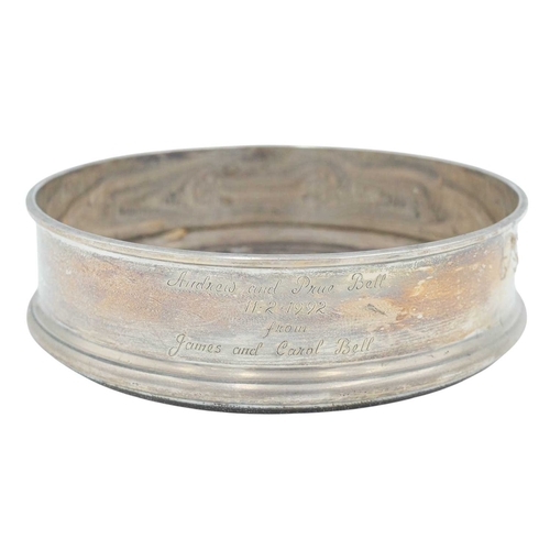 297 - A modern silver coaster. Diameter 12.5cm, with a presentation inscription, together with a silver pl... 