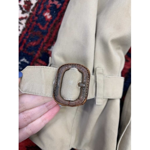 324 - Two Burberry trench coats. One black, one tan, both with a chest measurement of approximately 21