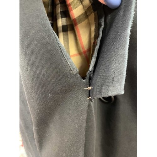 324 - Two Burberry trench coats. One black, one tan, both with a chest measurement of approximately 21