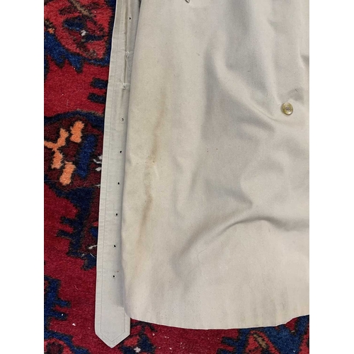 324 - Two Burberry trench coats. One black, one tan, both with a chest measurement of approximately 21