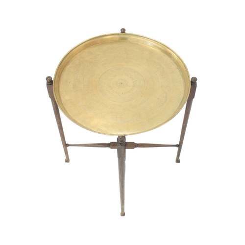 34 - An Eastern brass topped tray table. On a turned folding stand, height 71cm, diameter 57cm, together ... 