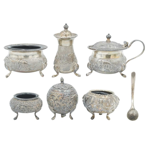 440 - An Indian Sterling silver three piece cruet set. Chased and embossed with elephants in landscapes, s... 