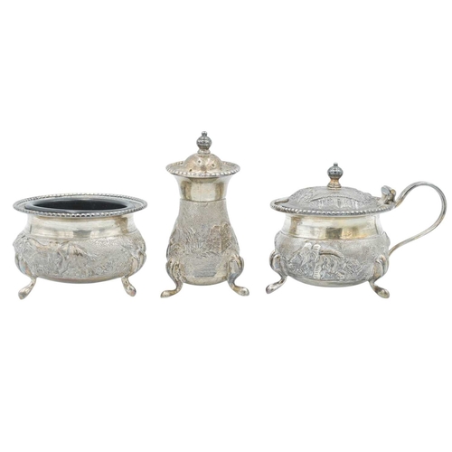 440 - An Indian Sterling silver three piece cruet set. Chased and embossed with elephants in landscapes, s... 