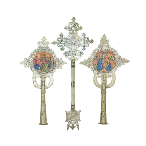 66 - Three Ethiopian ceremonial crucifixes. Formed of metal, two with cut out lattice designs and handpai... 