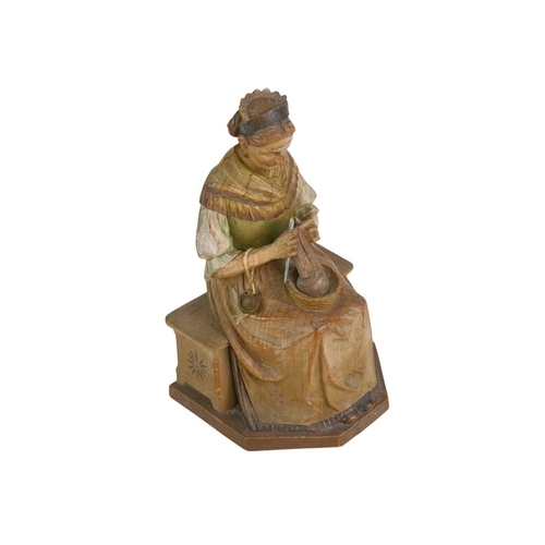 72 - A carved and painted pine figure of a lady knitting. 20th century, probably Flemish, height 19cm.