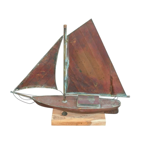 73 - A copper weathervane modelled as a yacht. 20th century. Later mounted on a yew wood base. Overall he... 