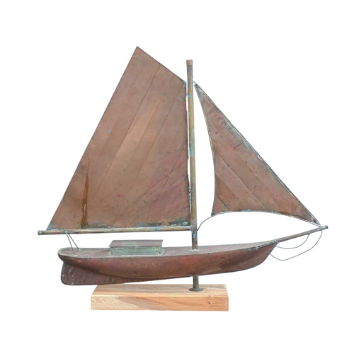 73 - A copper weathervane modelled as a yacht. 20th century. Later mounted on a yew wood base. Overall he... 