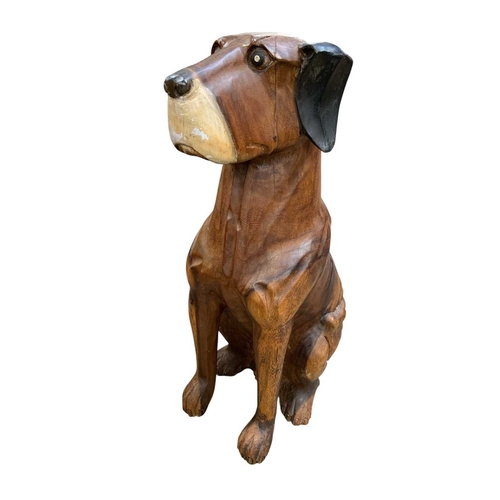 184 - A contemporary carved wood sculpture. Of a seated dog, acacia wood, height 76cm.