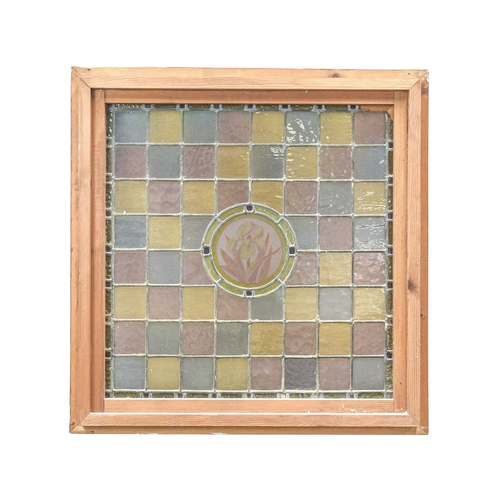208 - A framed stained glass panel. Leaded glass squares in pink, grey and yellow with a central floral ro... 