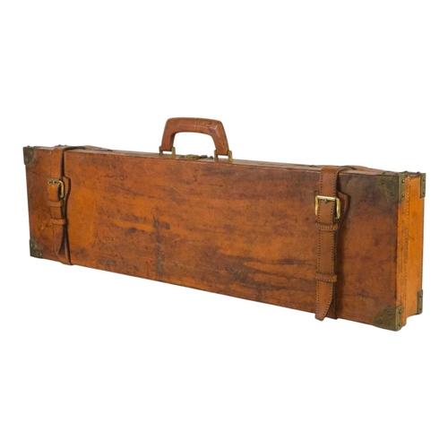 212 - A leather covered shotgun case. 20th century, with brass corner plates, securing straps, carrying ha... 