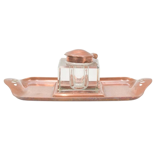 222 - An Art Nouveau copper inkstand. Glass inkwell with tulip shaped lid, the tray with cut-out decoratio... 
